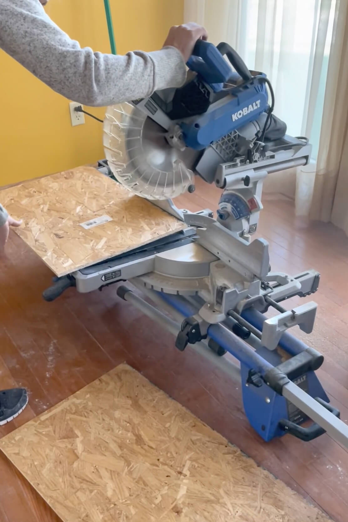 Using a miter saw to cut wood to make an arched doorway.